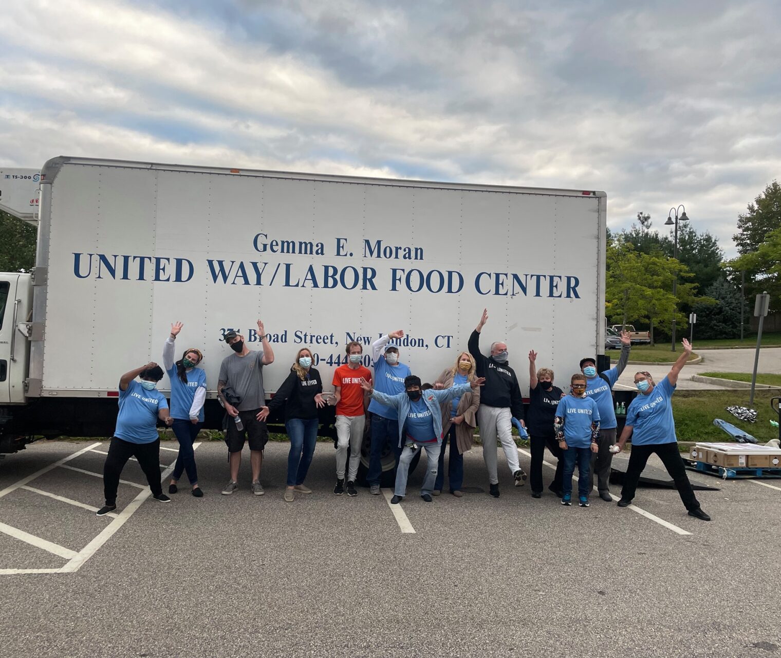 United Way of Southeastern Connecticut volunteers cheering in front of a delivery truck