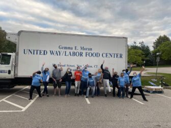 United Way of Southeastern Connecticut volunteers cheering in front of a delivery truck