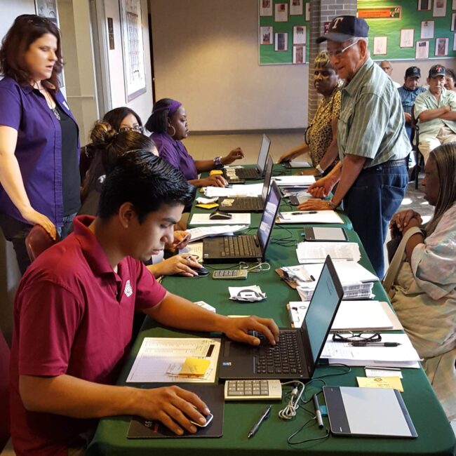 Who We Serve- Community Action Agencies- Hero Image Organization and community action workers check in clients during intake