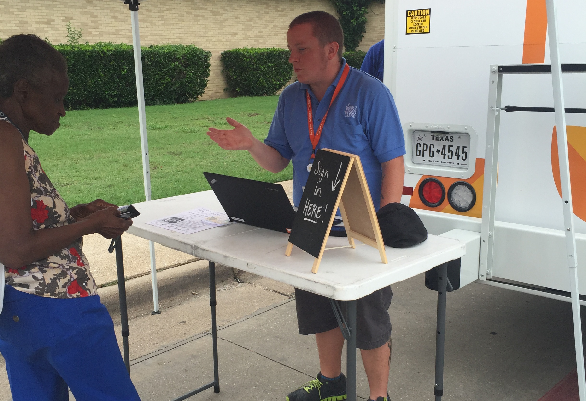 Case Management worker speaking to client at a mobile distribution