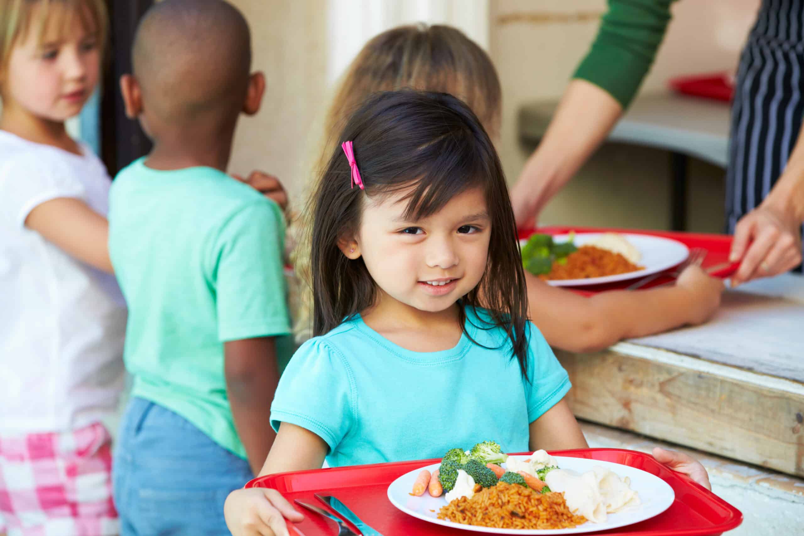 Girl with tray of food at CACFP & SFSP distribution