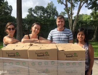 Volunteers and food bank employees gathered around food bank boxes of food