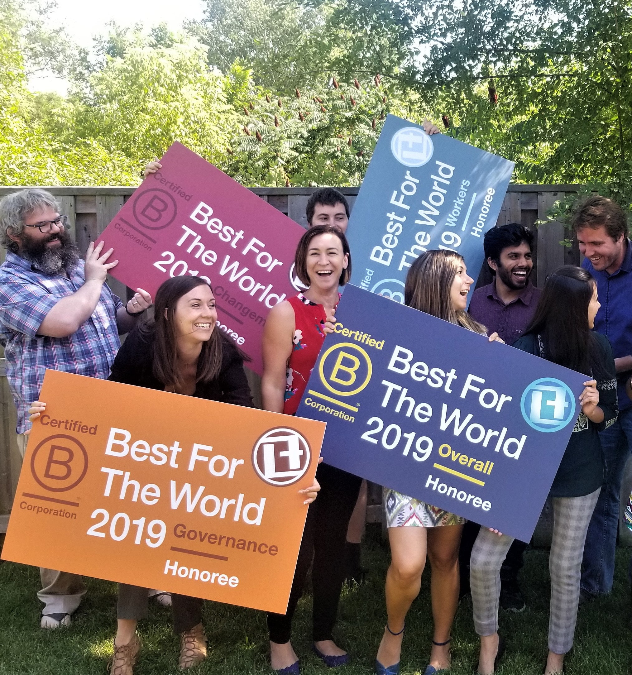 Link2Feed team posing with BCorp Best for the World Signs