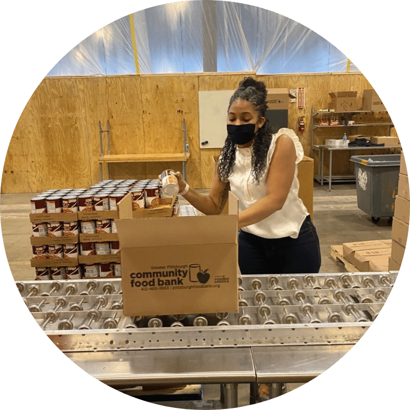 Volunteer loading food into a box at a food bank