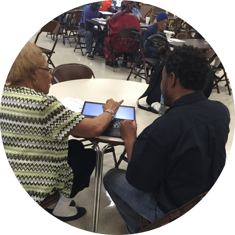 Woman explaining to man how to use Nonprofit Case Management Software on a laptop